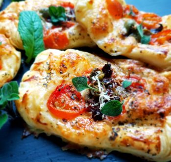 Przekąski z ciasta francuskiego z pomidorami, mozzarellą i oliwkami